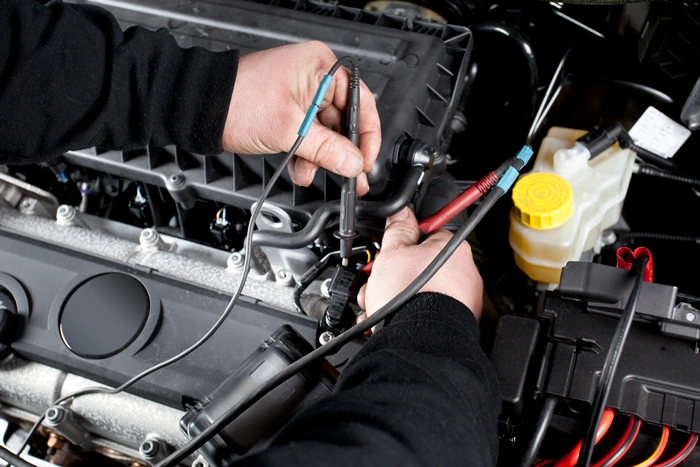 Mechanic checking electrical system on car