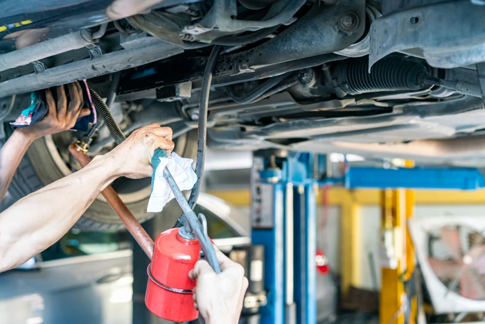 repairman or mechanic during use inject gun flush oil for cleaning in inside cooling tube for modify or development cooling system of automobile gasoline or diesel engine at garage