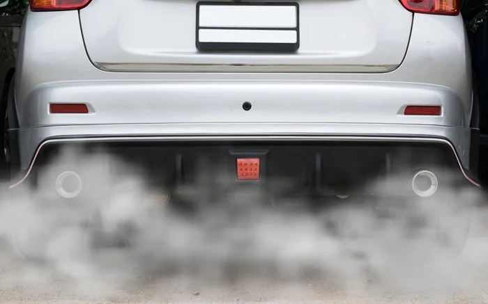 combustion fumes coming out of car exhaust pipe